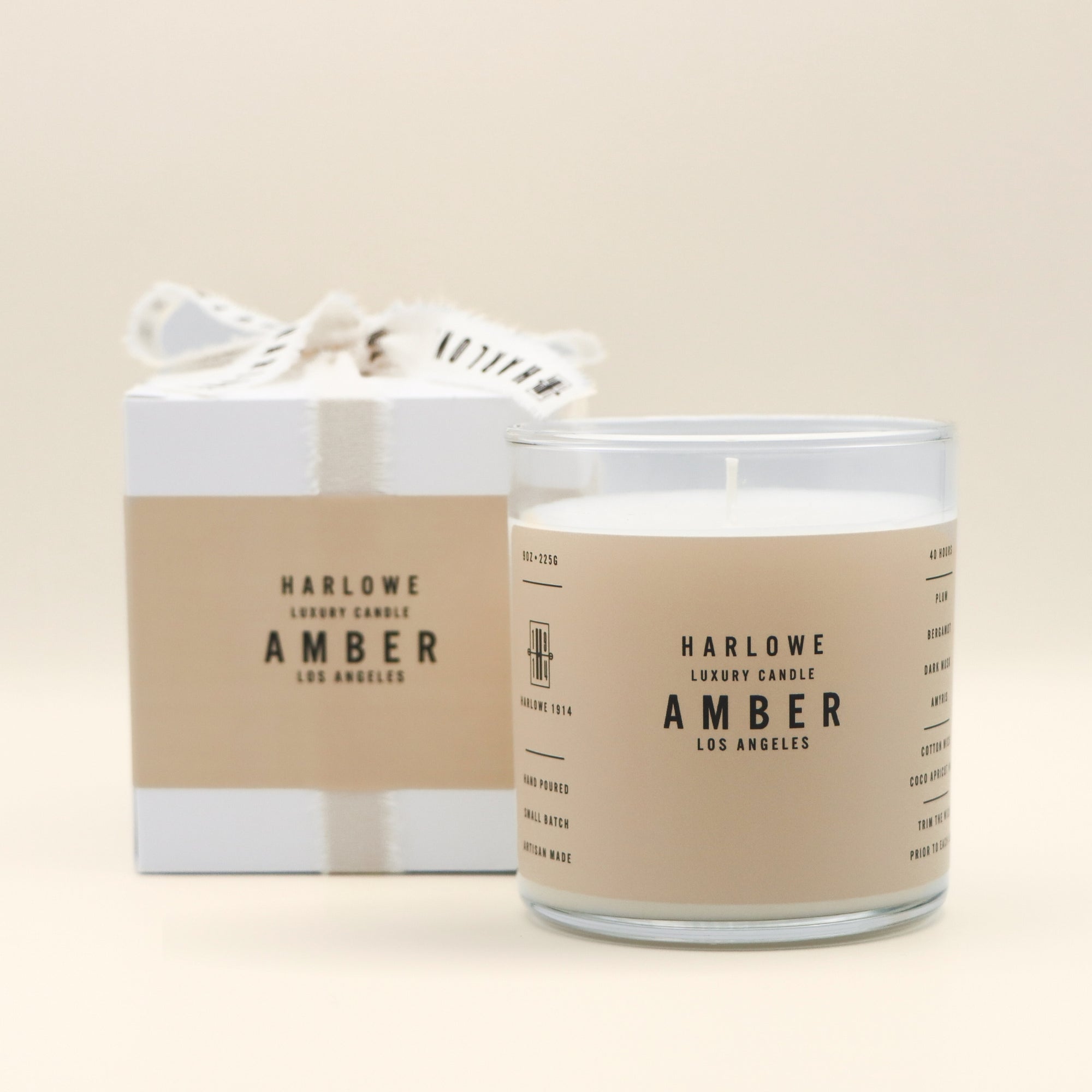 Harlowe Luxury Amber Candle with packaging on a beige background