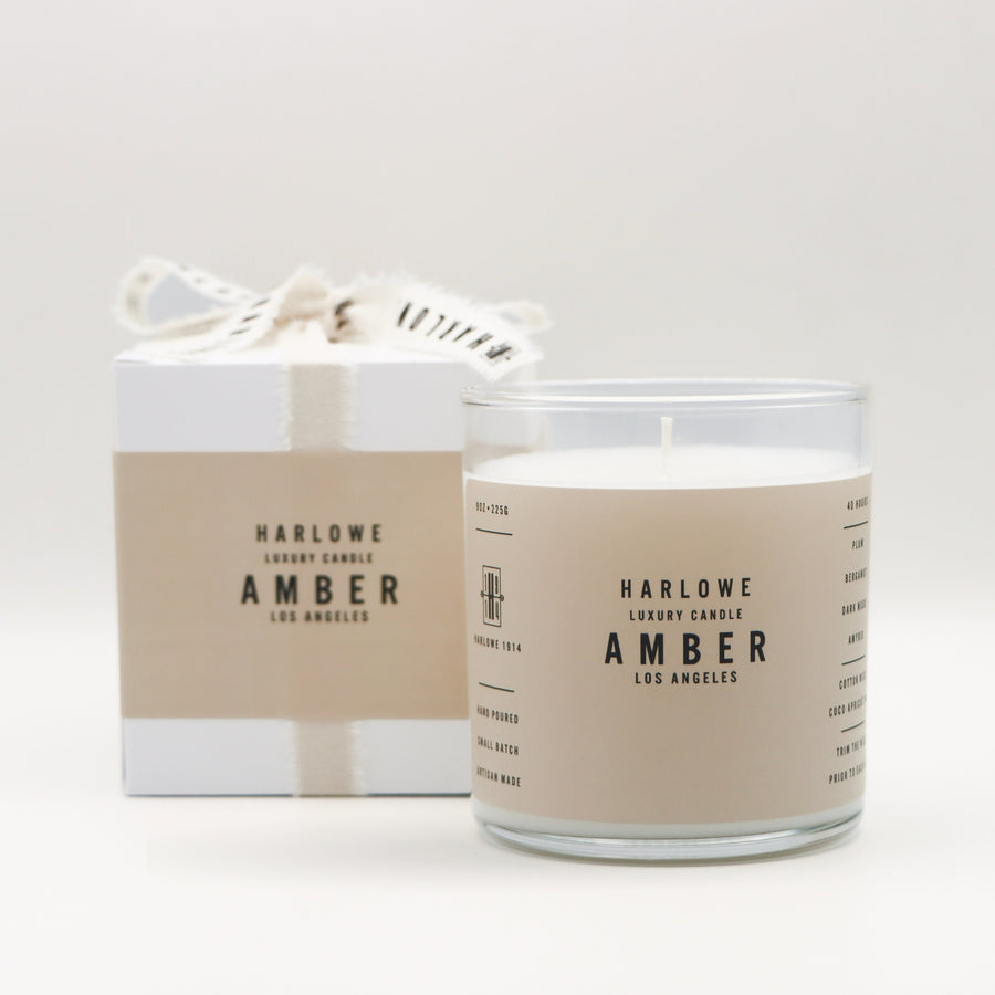 Harlowe Luxury Candle Amber with candle and box on a light gray background