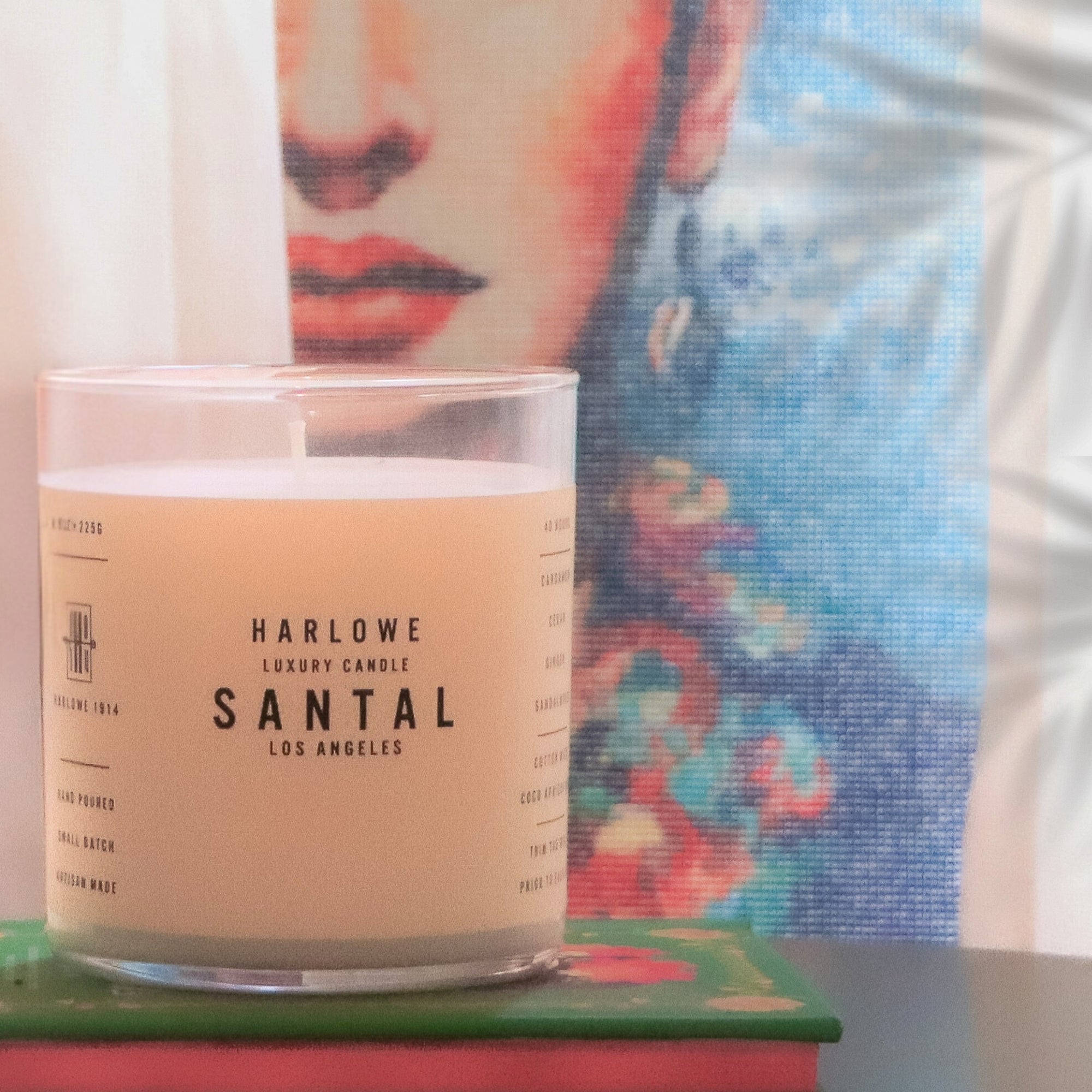 Harlowe Santal candle with a colorful abstract painting in the background