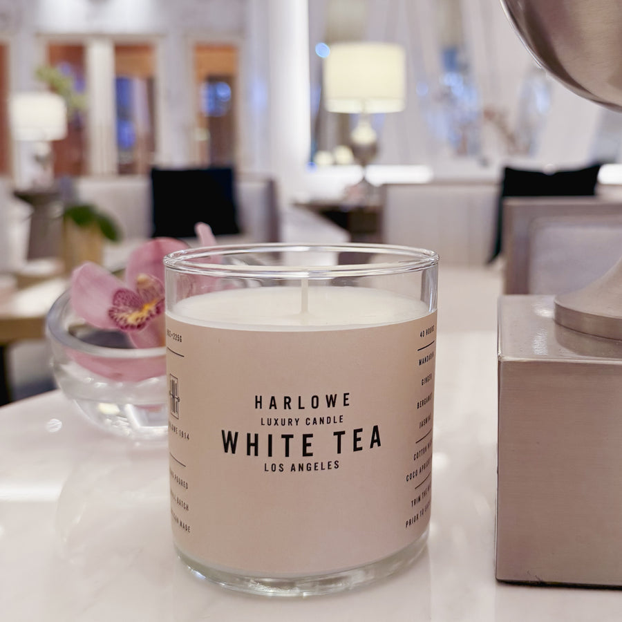 Harlowe Luxury Candle White Tea on a marble  table with indoor background with flowers